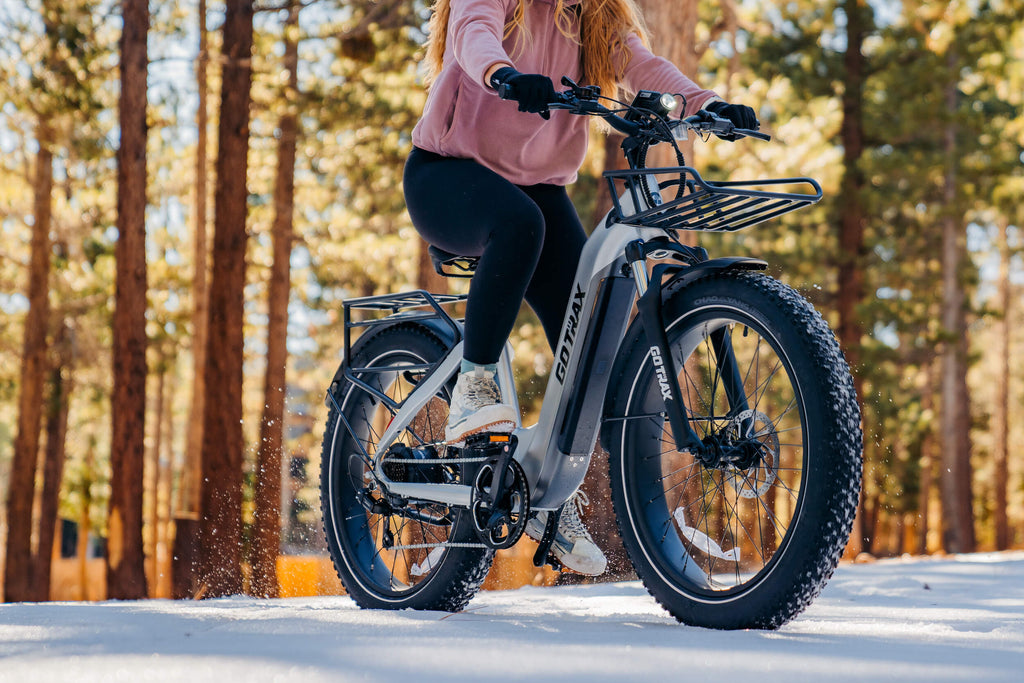 A woman riding the GOTRAX Tundra fat tire electric bike with a 750 watt hub motor and a torque sensor.